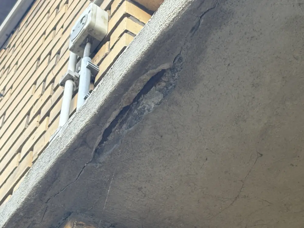 Scheur in een betonlatei boven een winkelpui