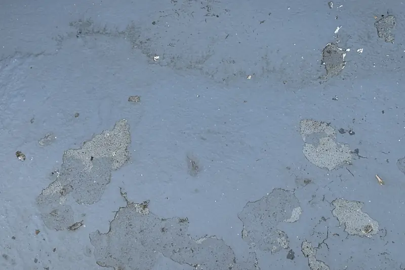 Loslatende grijze coating op een betonnen balkonvloer