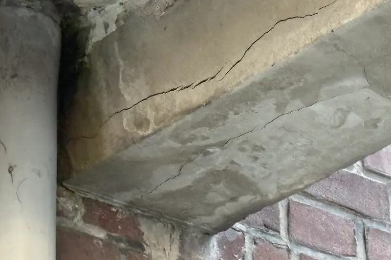 Scheuren in een betonnen console onder een balkon